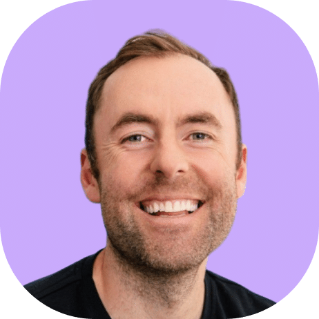 A man with short brown hair and a trimmed beard is smiling broadly. He is wearing a black Highline 2025 shirt and is set against a light purple background with rounded corners.
